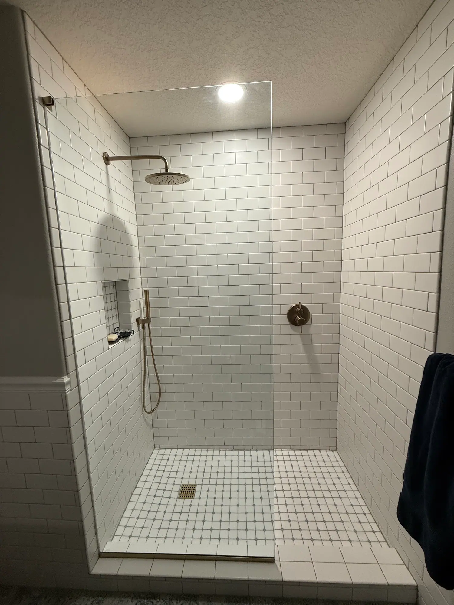 Tiled walk-in shower with glass panel
