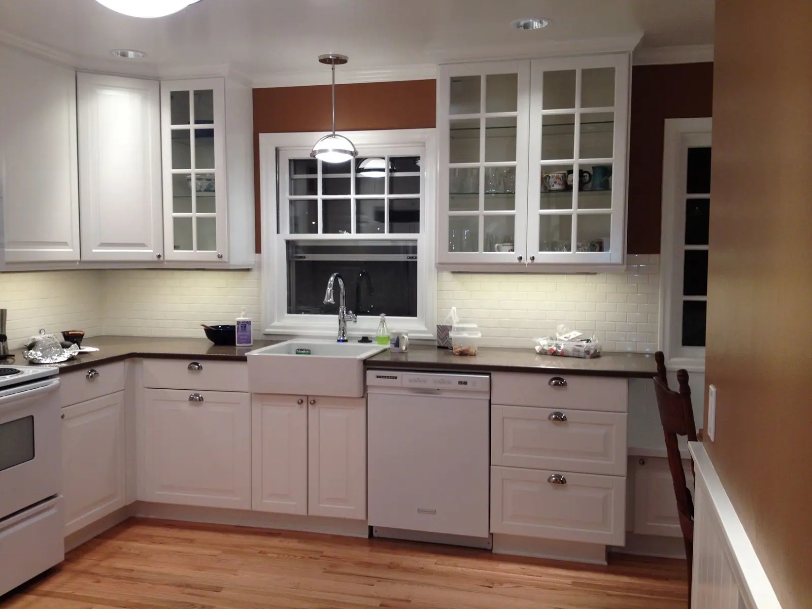Kitchen with white cabinets, farmhouse sink and lights under the upper cabinets