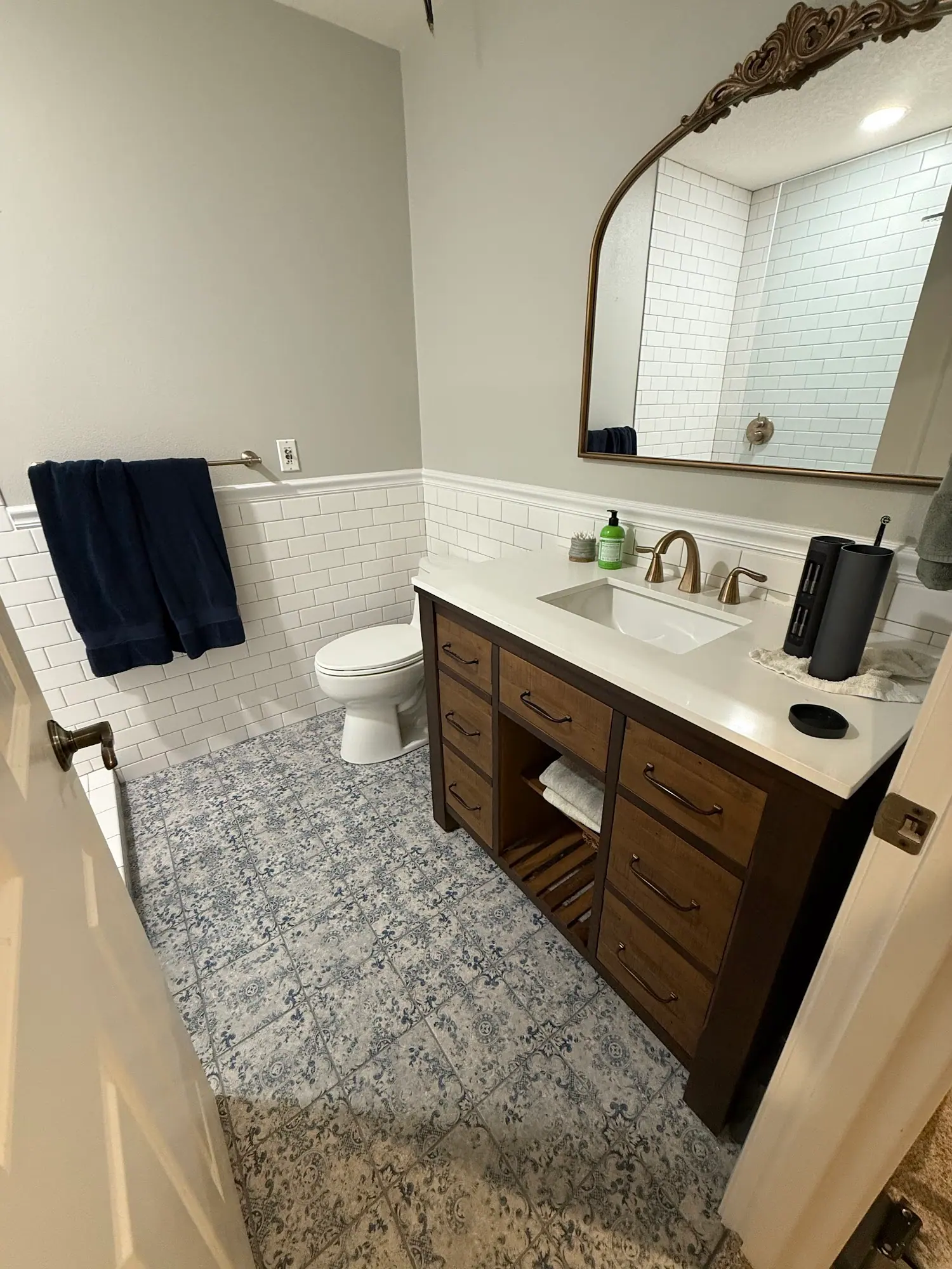Bathroom with wood vanity and patterned tile floor